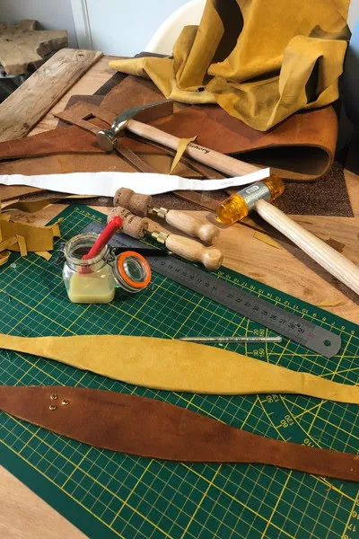Materialen en hulpmiddelen op een tafel om een leren halsband te maken