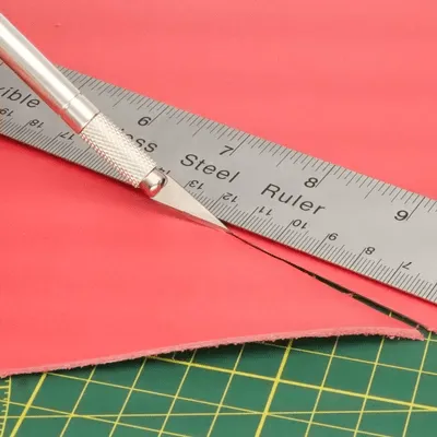 Leder snijden met precisiemesje en metalen liniaal